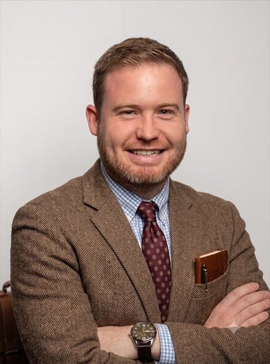 Matthew Butler in a tweed jacket and tie, dressed as a grammar-loving scholar