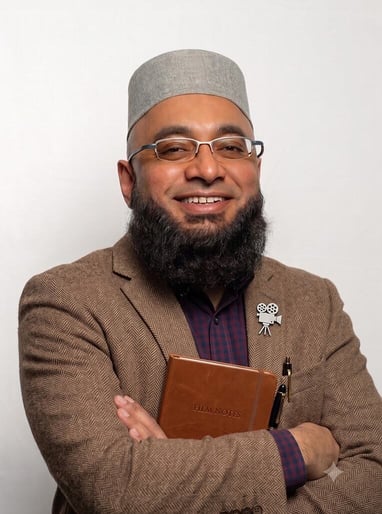 Ahmad Mahomed in a tweed jacket with a notebook, dressed as a film buff